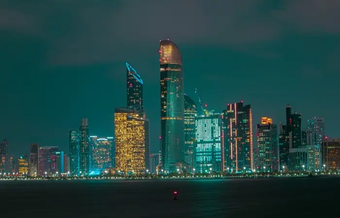 Skyline di Abu Dhabi di sera lungo la Corniche