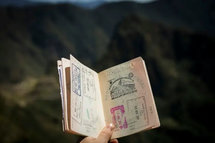 Passaporto con timbri di visto in mano, a richiamo dei nuovi residenti